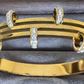 Gold bracelet with diamond accents on a gray surface