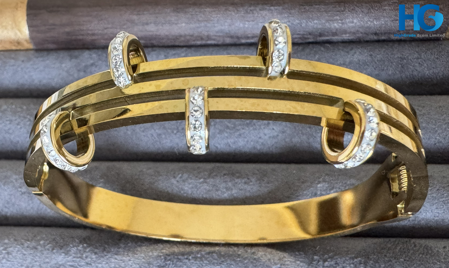Gold bracelet with diamond accents on a gray surface